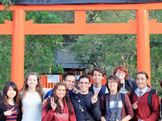 UC Davis students pose in front of a shinto shrine in japan.